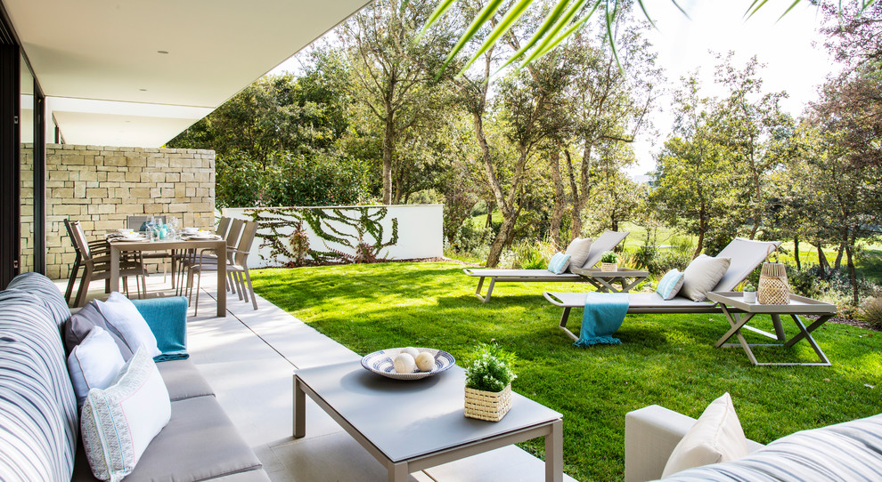 Mid-sized contemporary backyard patio in Barcelona with a roof extension.
