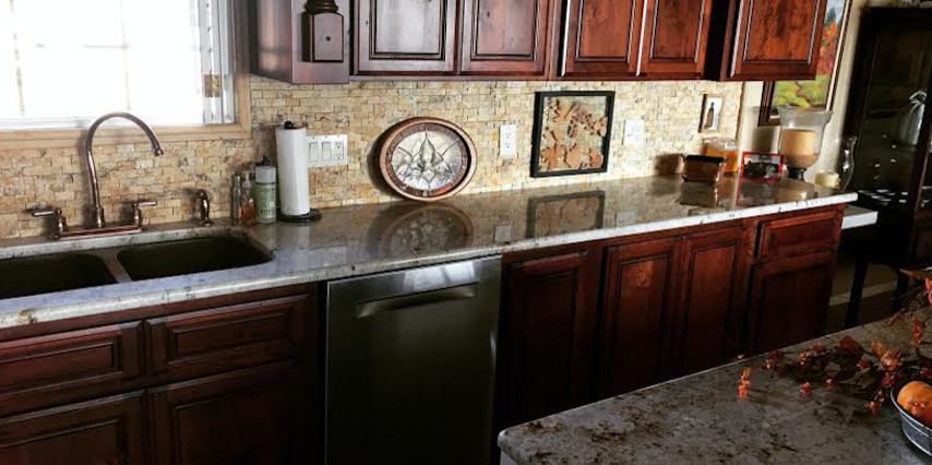 Example of a mid-sized transitional l-shaped porcelain tile enclosed kitchen design in Austin with a double-bowl sink, beaded inset cabinets, dark wood cabinets, granite countertops, beige backsplash, stone tile backsplash, stainless steel appliances and a peninsula
