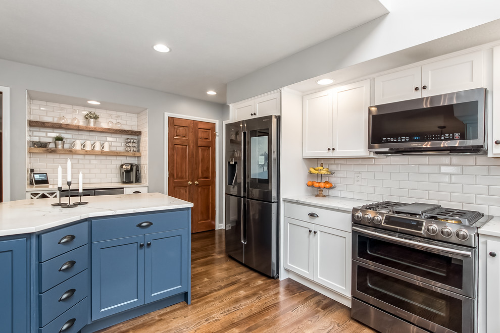 Example of a large transitional u-shaped eat-in kitchen design in Columbus with shaker cabinets, quartz countertops, white backsplash and an island