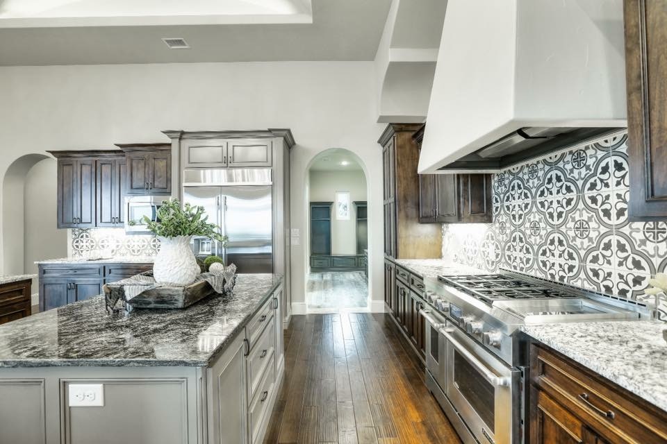 Inspiration for a huge transitional u-shaped dark wood floor eat-in kitchen remodel in Austin with recessed-panel cabinets, dark wood cabinets, granite countertops, multicolored backsplash, porcelain backsplash, stainless steel appliances, two islands and a farmhouse sink