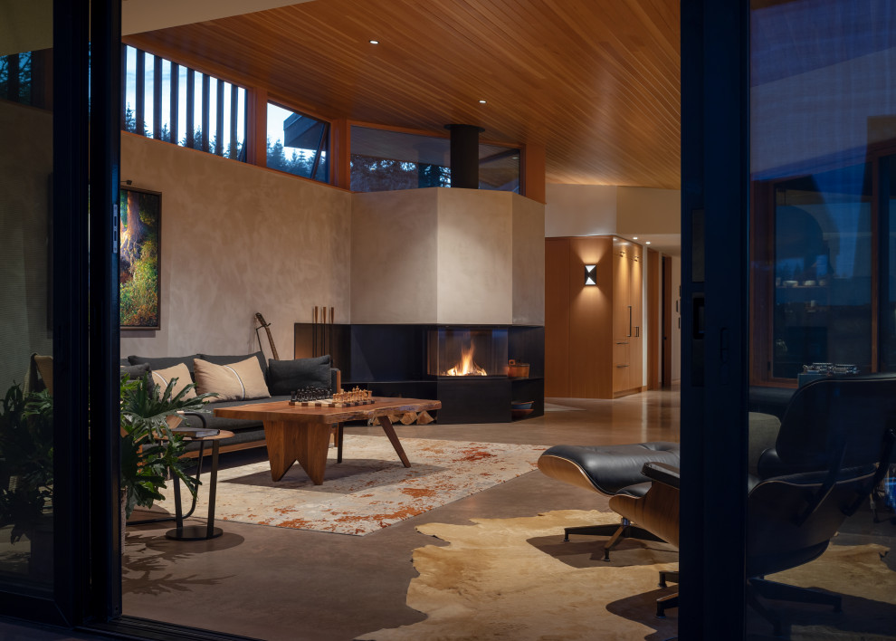 Mittelgroßes, Fernseherloses Modernes Wohnzimmer mit beiger Wandfarbe, Betonboden, Eckkamin, Kaminumrandung aus Metall, grauem Boden und Holzdecke in Portland