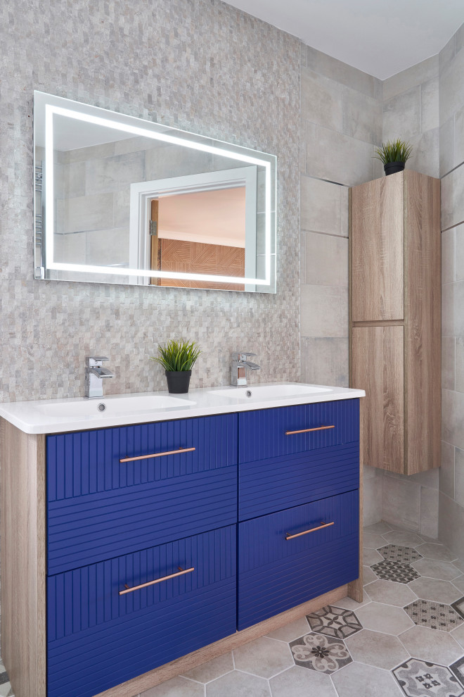 Inspiration pour une salle de bain principale design de taille moyenne avec un placard à porte affleurante, des portes de placard bleues, un carrelage gris, des carreaux de porcelaine, un sol en carrelage de porcelaine, un sol gris, un plan de toilette blanc, meuble double vasque et meuble-lavabo sur pied.