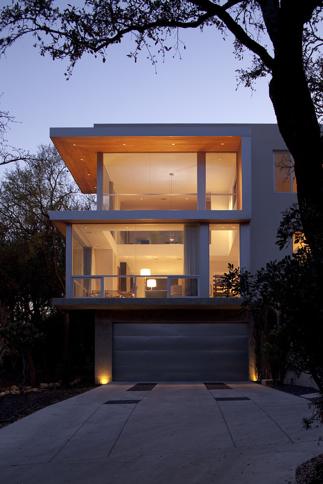 Photo of a large modern two-storey white exterior in Austin with wood siding and a flat roof.