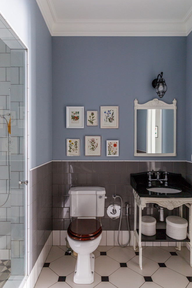 Idee per una stanza da bagno tradizionale con WC a due pezzi, piastrelle grigie, pareti blu, lavabo sottopiano, top nero, un lavabo e mobile bagno freestanding