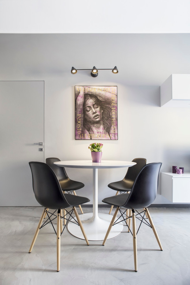 This is an example of a mid-sized contemporary dining room in Milan with grey walls and concrete floors.