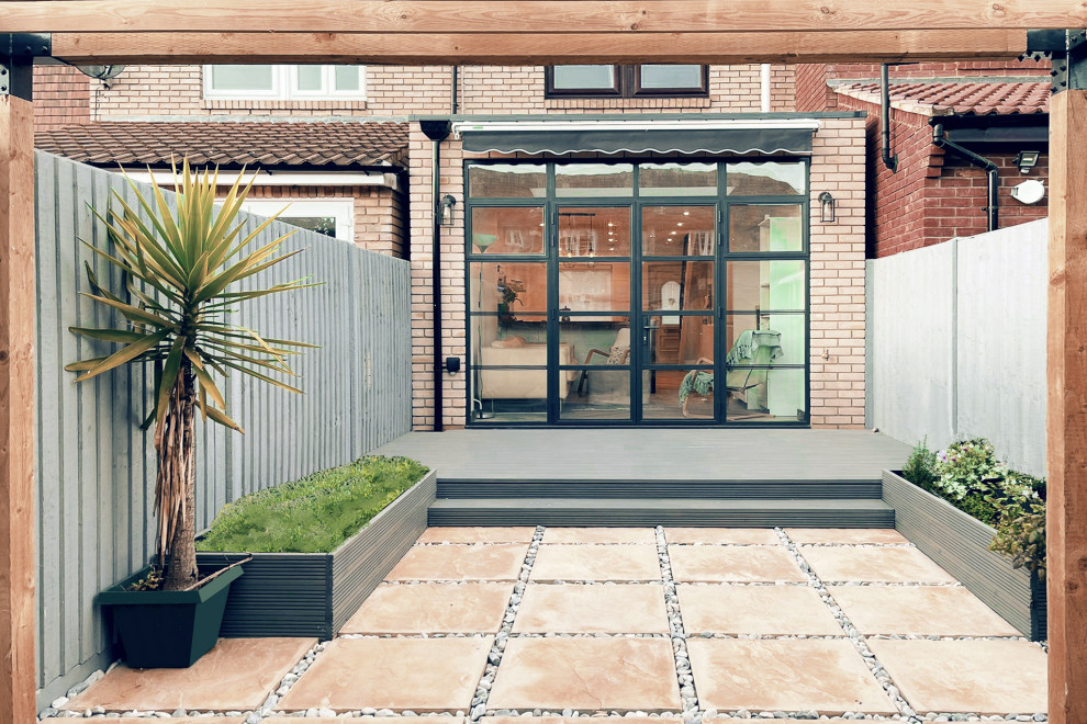 Design ideas for a small contemporary back driveway full sun pergola for summer in London with concrete paving and a wood fence.