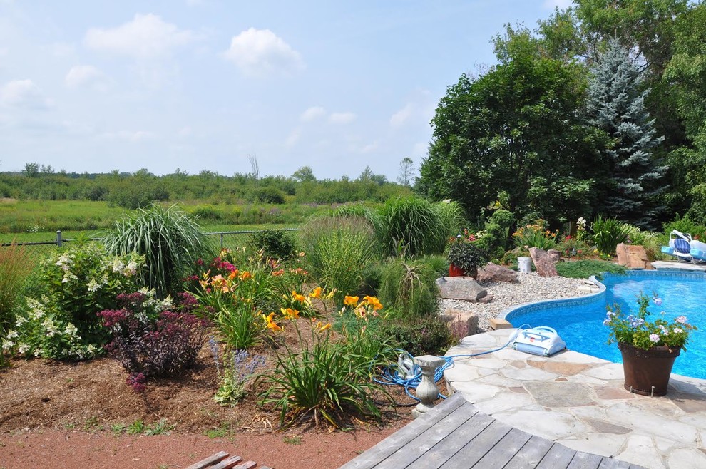 Photo of a large transitional backyard stone landscaping in Ottawa.