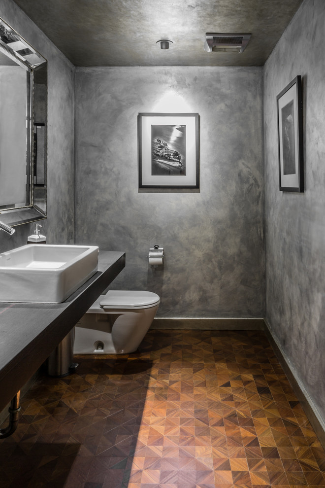 Mid-sized modern powder room in Los Angeles with wood benchtops, medium hardwood floors and grey benchtops.