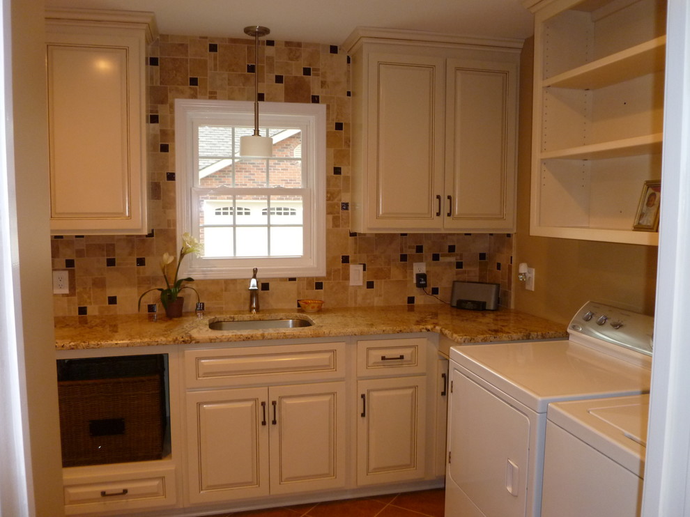 Photo of a large traditional l-shaped dedicated laundry room in Nashville with a single-bowl sink, raised-panel cabinets, beige cabinets, granite benchtops, beige walls, porcelain floors and a side-by-side washer and dryer.