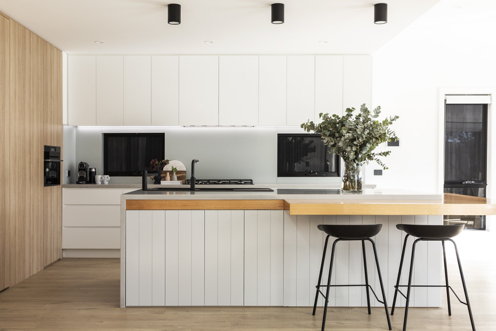 Modern kitchen in Sydney with a built-in sink, raised-panel cabinets, grey cabinets, engineered stone countertops, grey splashback, laminate floors and grey worktops.