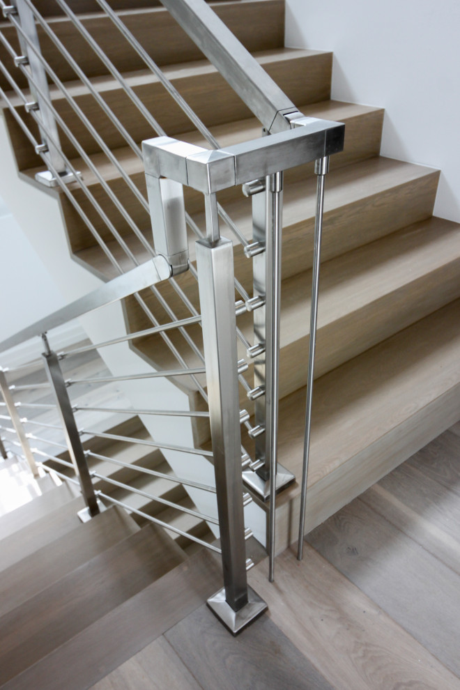Inspiration for a mid-sized modern wood floating staircase in DC Metro with wood risers, metal railing and planked wall panelling.