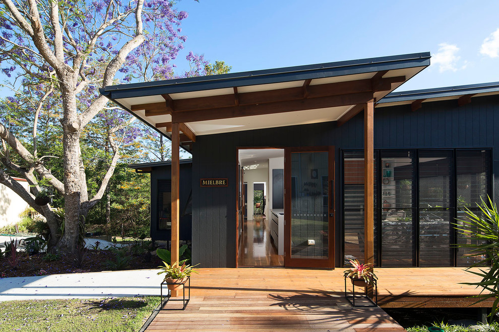 Design ideas for a small modern one-storey black house exterior in Brisbane with concrete fiberboard siding, a flat roof and a metal roof.