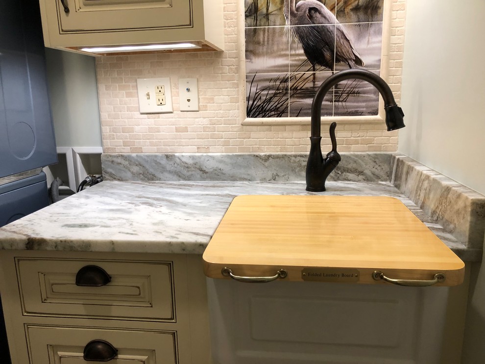 Small beach style single-wall dedicated laundry room in Baltimore with a farmhouse sink, beaded inset cabinets, distressed cabinets, granite benchtops, green walls, ceramic floors, a stacked washer and dryer, brown floor and brown benchtop.