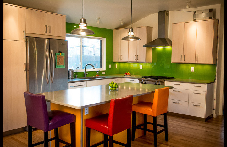 Design ideas for a large contemporary l-shaped eat-in kitchen in Denver with an undermount sink, flat-panel cabinets, light wood cabinets, granite benchtops, green splashback, glass tile splashback, stainless steel appliances, medium hardwood floors and with island.