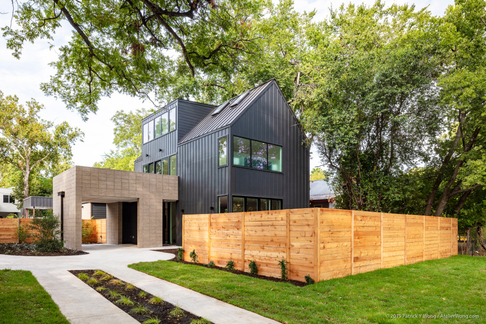Cette image montre une grande façade de maison noire minimaliste en planches et couvre-joints à un étage avec un revêtement mixte, un toit en appentis, un toit mixte et un toit noir.