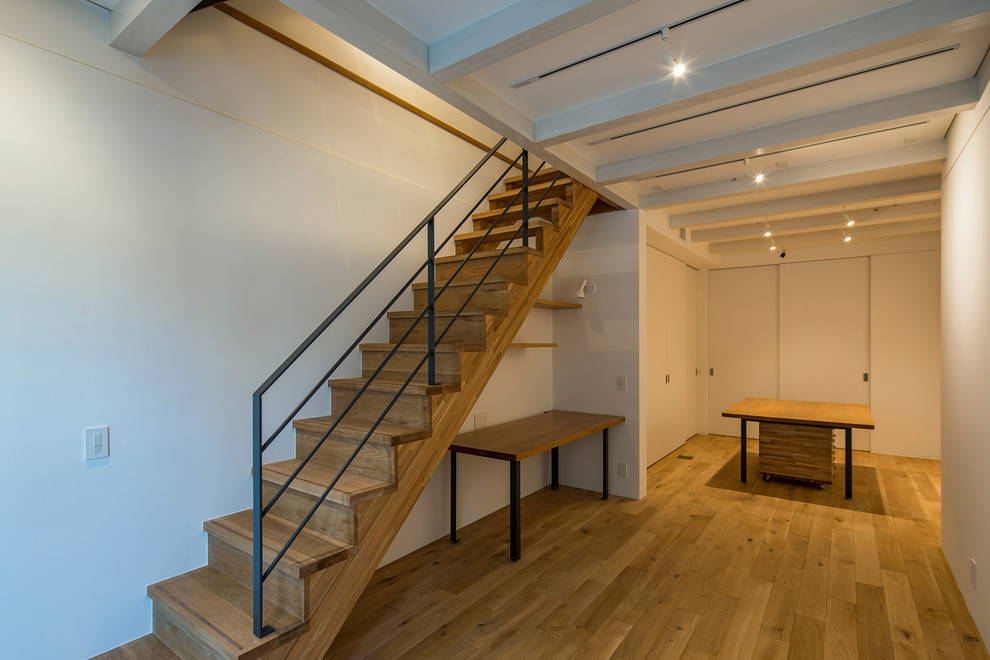 Inspiration for a contemporary look-out basement in Tokyo with white walls and plywood floors.