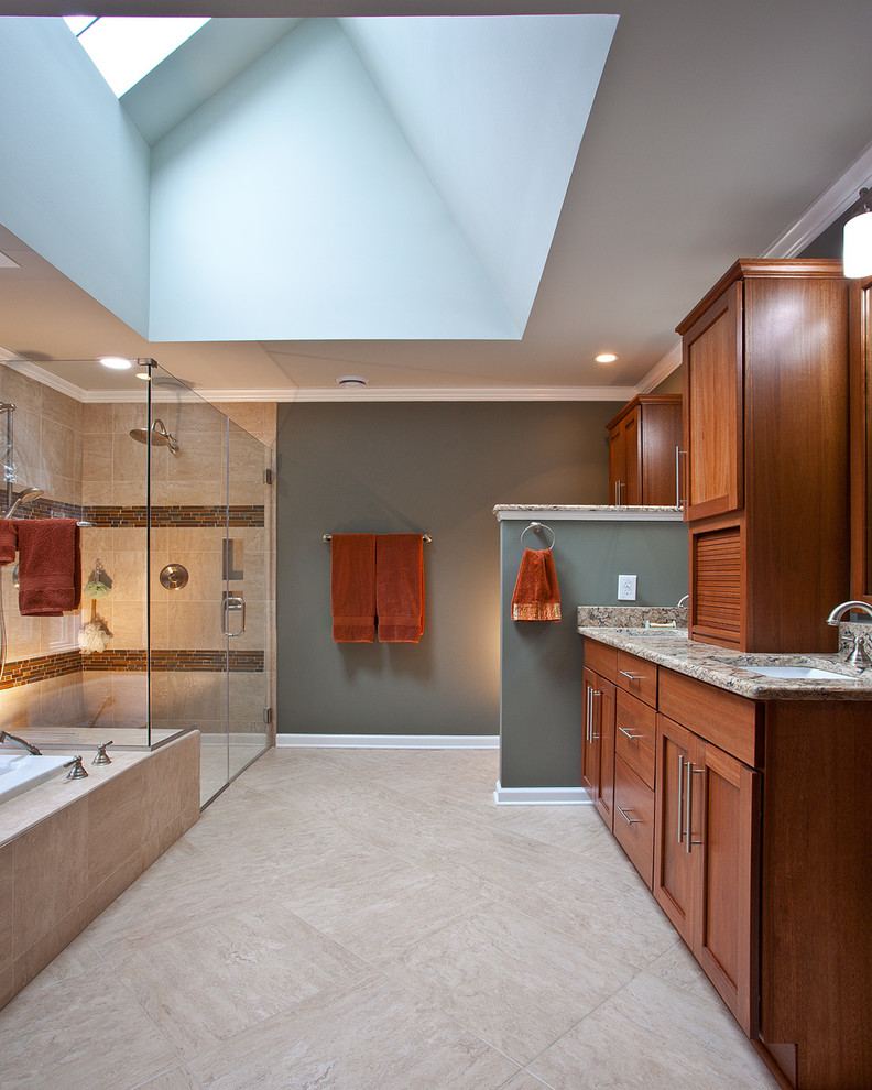 This is an example of a large transitional master bathroom in Raleigh with shaker cabinets, medium wood cabinets, a drop-in tub, a curbless shower, a two-piece toilet, beige tile, terra-cotta tile, grey walls, travertine floors, an undermount sink, quartzite benchtops, grey floor, a hinged shower door and multi-coloured benchtops.