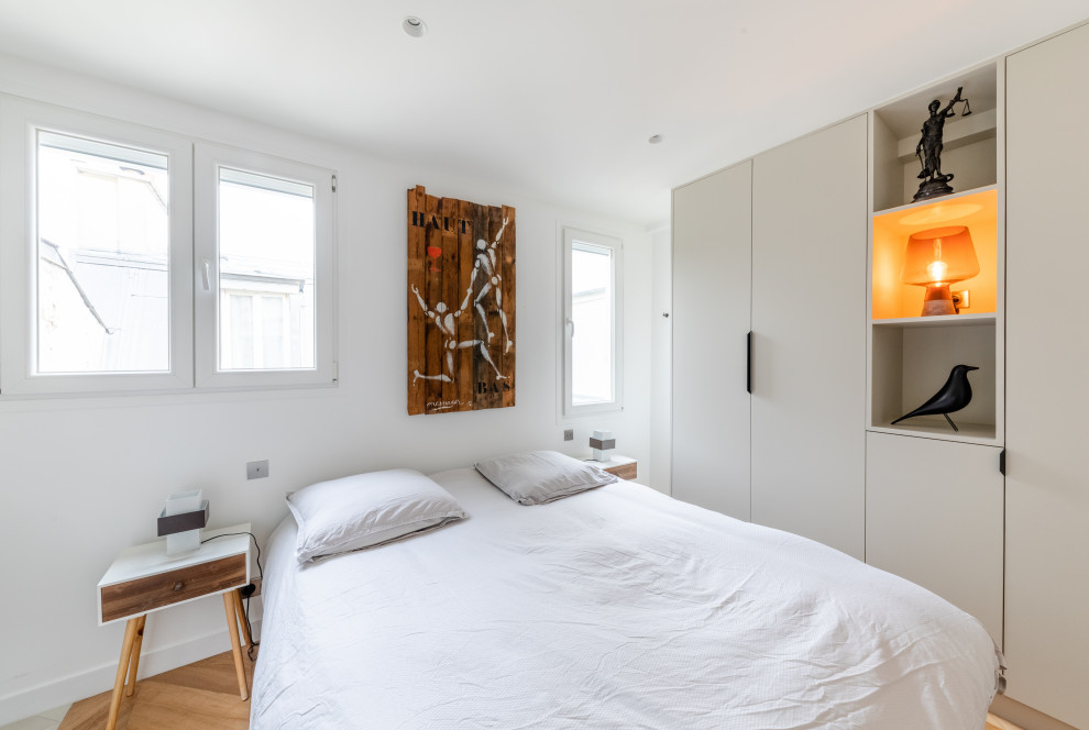 Bild på ett funkis sovrum, med vita väggar, marmorgolv och brunt golv