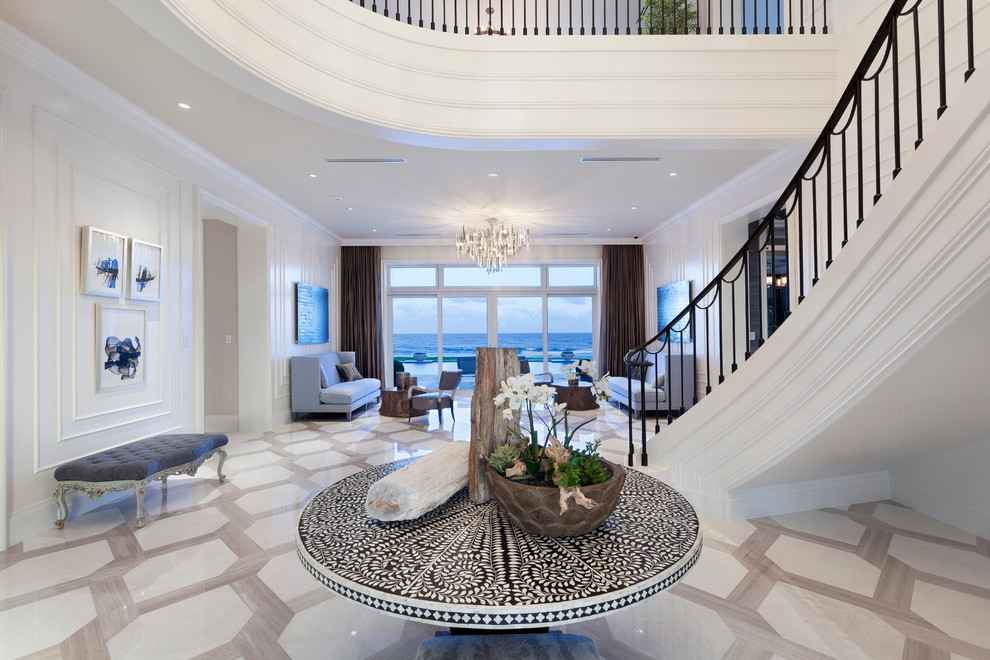 This is an example of an expansive contemporary foyer in Miami with marble floors and a double front door.