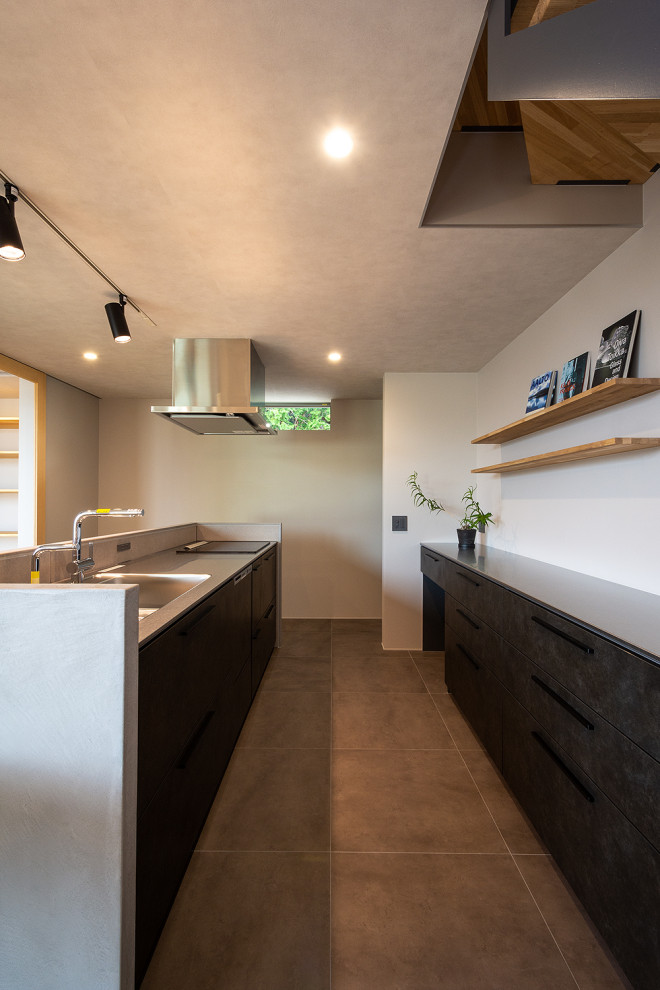 Idéer för ett mellanstort nordiskt grå linjärt kök med öppen planlösning, med en integrerad diskho, släta luckor, svarta skåp, bänkskiva i rostfritt stål, vitt stänkskydd, svarta vitvaror, mellanmörkt trägolv, en köksö och beiget golv