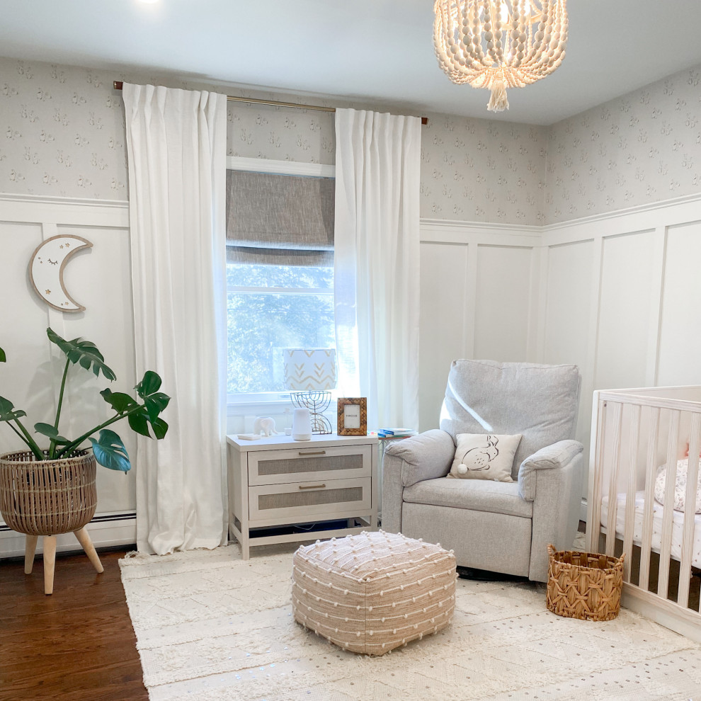 Foto di una cameretta per neonata stile shabby di medie dimensioni con pareti bianche, pavimento in legno massello medio, pavimento marrone e carta da parati