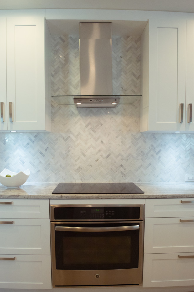 Inspiration for a mid-sized transitional galley ceramic tile and beige floor eat-in kitchen remodel in Miami with an undermount sink, shaker cabinets, white cabinets, granite countertops, gray backsplash, stone tile backsplash, stainless steel appliances and a peninsula