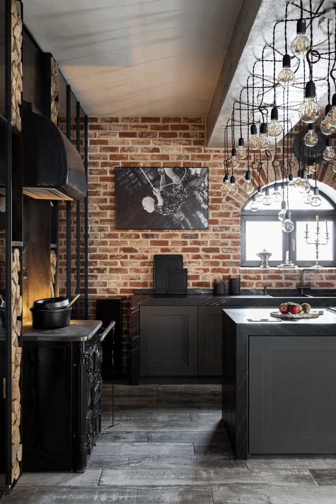 This is an example of a mid-sized contemporary l-shaped kitchen in Moscow with a double-bowl sink, open cabinets, grey cabinets, brown splashback, brick splashback, black appliances, with island, grey floor, black benchtop and exposed beam.