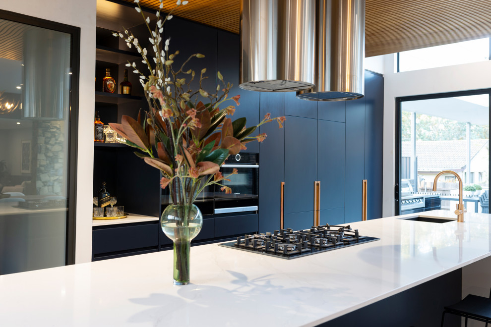 Inspiration for a large modern galley open plan kitchen in Canberra - Queanbeyan with an undermount sink, blue cabinets, quartz benchtops, black appliances, porcelain floors, with island, grey floor and white benchtop.