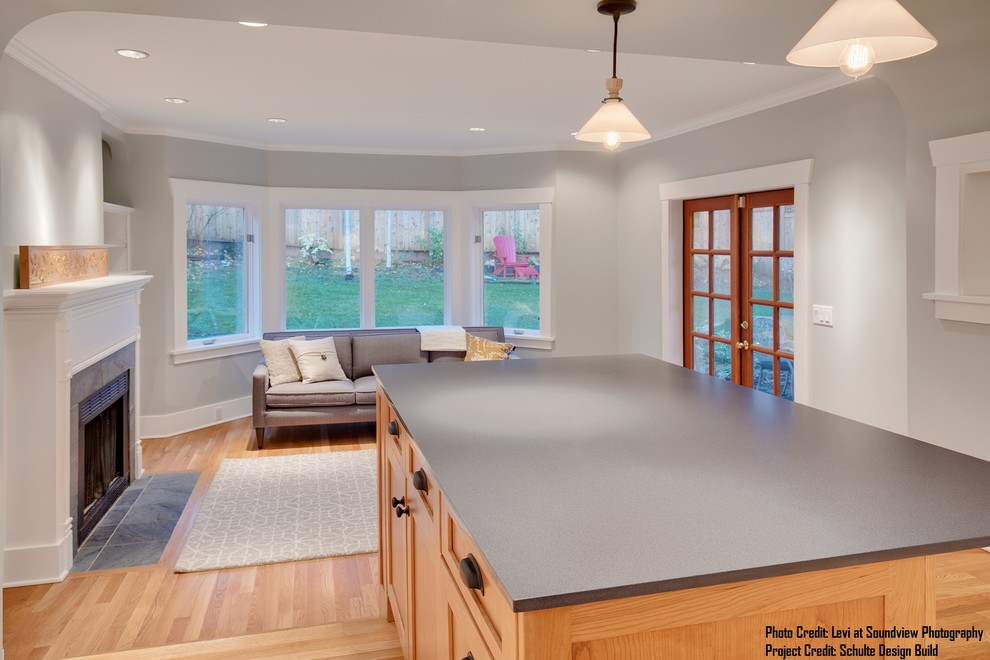 Example of a large transitional l-shaped medium tone wood floor and brown floor open concept kitchen design in Seattle with an undermount sink, shaker cabinets, white cabinets, quartz countertops, white backsplash, subway tile backsplash, stainless steel appliances and an island