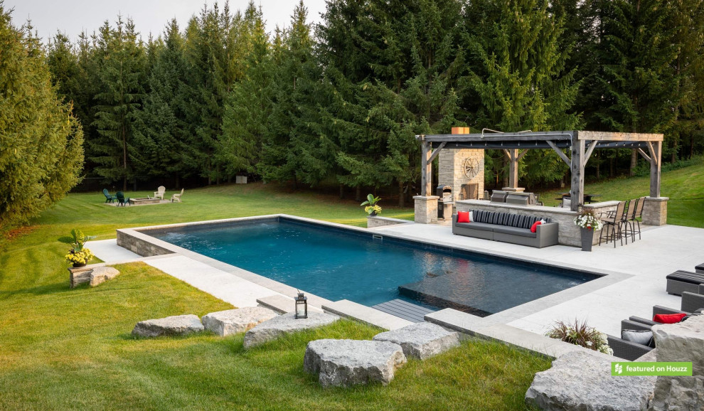 Inspiration for a large country backyard rectangular pool in Toronto with with a pool and stamped concrete.