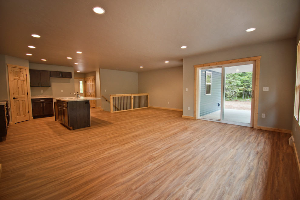 Mid-sized mountain style l-shaped medium tone wood floor and brown floor eat-in kitchen photo with a double-bowl sink, recessed-panel cabinets, dark wood cabinets, an island and gray countertops