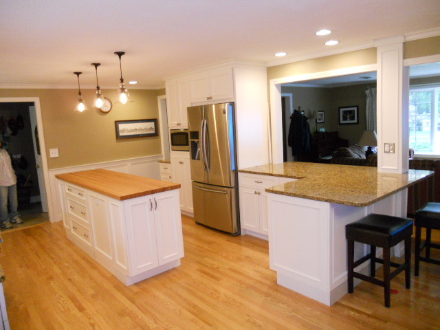 Inspiration for a large transitional l-shaped eat-in kitchen in Boston with beaded inset cabinets, white cabinets, granite benchtops, stainless steel appliances, light hardwood floors and with island.