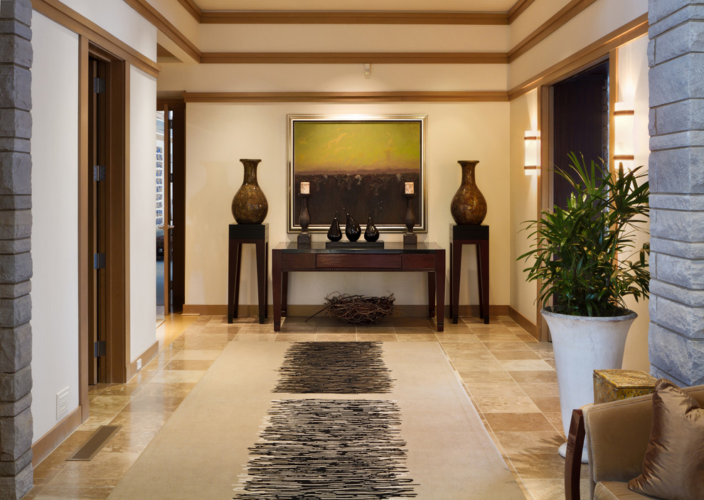 Photo of an expansive transitional hallway in Omaha with white walls, travertine floors and brown floor.