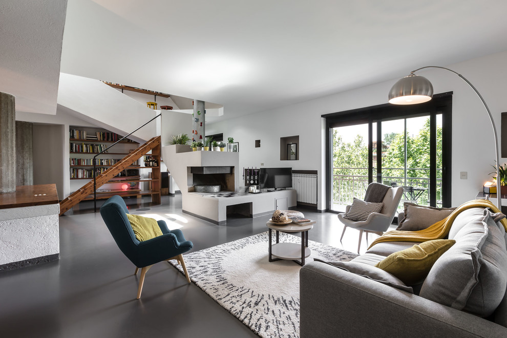 This is an example of a large contemporary open concept living room in Milan with white walls, porcelain floors, a corner fireplace, a plaster fireplace surround and a freestanding tv.
