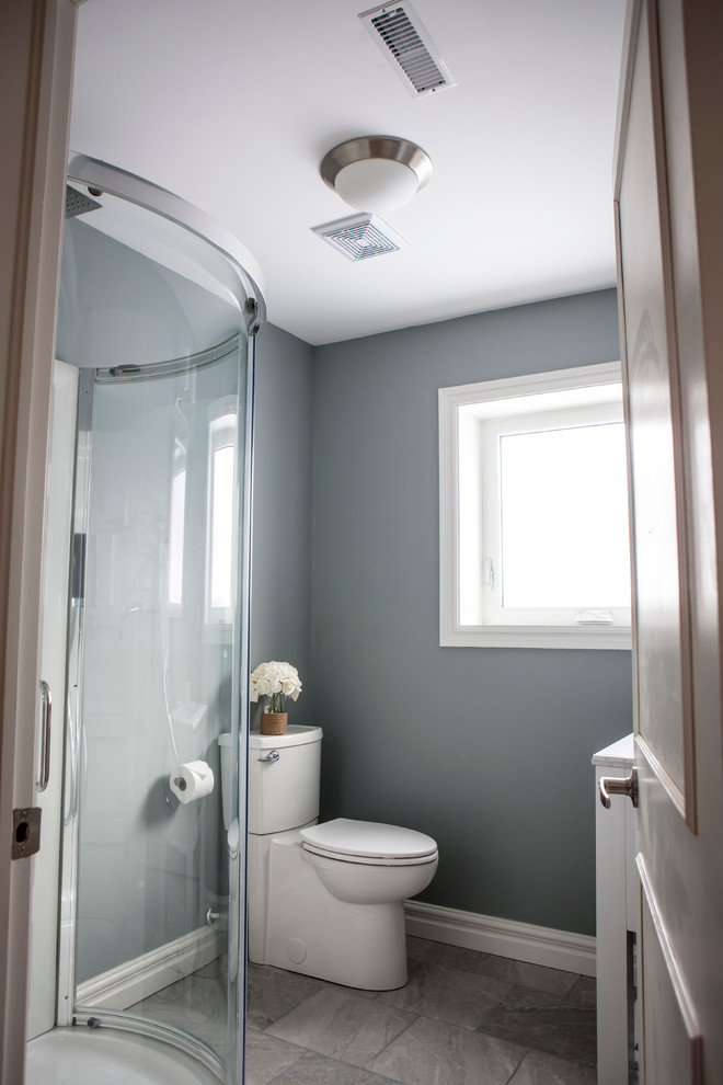 Mid-sized transitional beige tile and porcelain tile ceramic tile corner shower photo with an undermount sink, shaker cabinets, white cabinets, marble countertops, a one-piece toilet and gray walls