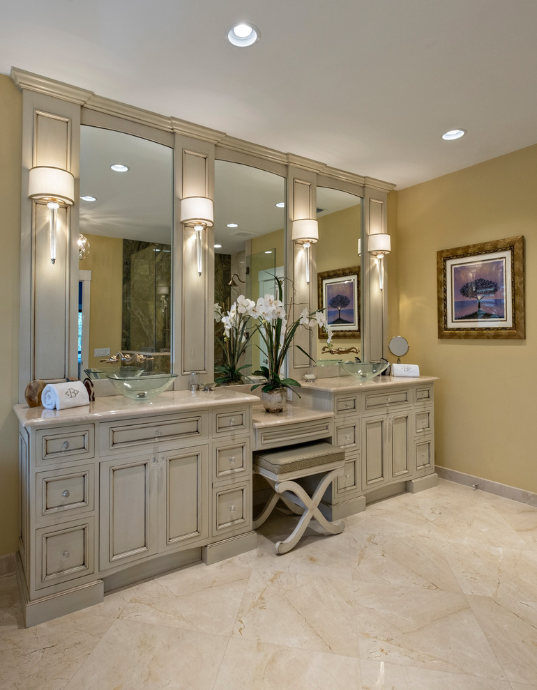 Freestanding bathtub - large transitional master porcelain tile, double-sink and wallpaper freestanding bathtub idea with beaded inset cabinets, distressed cabinets, beige walls, a vessel sink, beige countertops and a built-in vanity