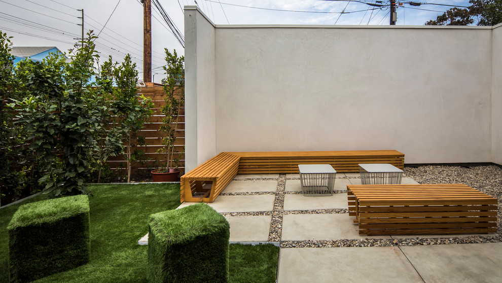 This is an example of a mid-sized modern backyard patio in Los Angeles with concrete pavers and no cover.