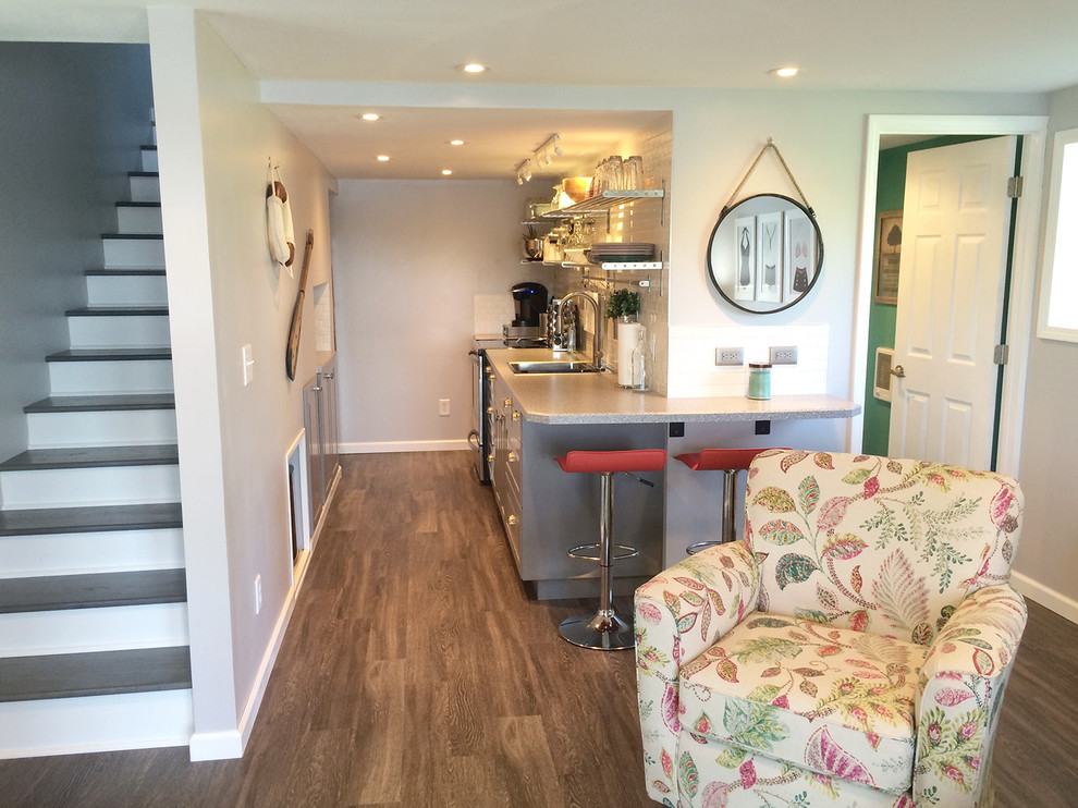 Inspiration for a small contemporary galley medium tone wood floor eat-in kitchen remodel in Other with a single-bowl sink, recessed-panel cabinets, gray cabinets, white backsplash, subway tile backsplash, stainless steel appliances and no island