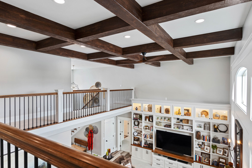 This is an example of a large classic open plan games room in Other with grey walls, carpet, a standard fireplace, a stone fireplace surround, a built-in media unit, grey floors and a coffered ceiling.