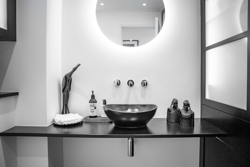 Photo of a small contemporary bathroom in Kent with black cabinets, a one-piece toilet, wood benchtops, red floor, black benchtops, a single vanity and a floating vanity.