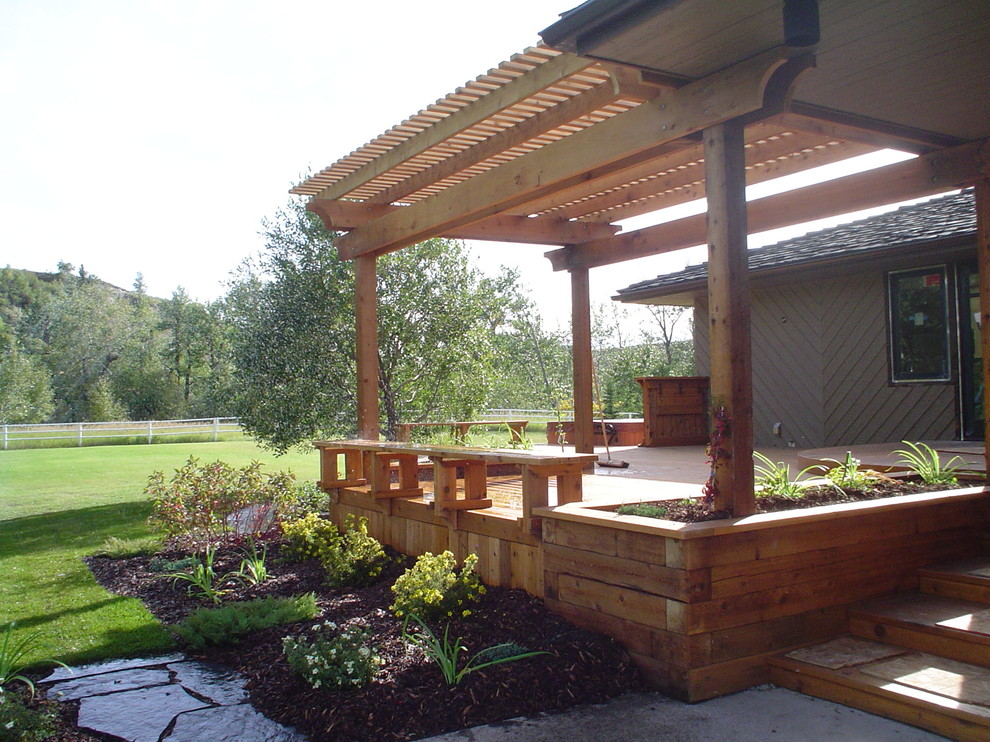 Design ideas for a mid-sized transitional backyard deck in Calgary with a pergola.