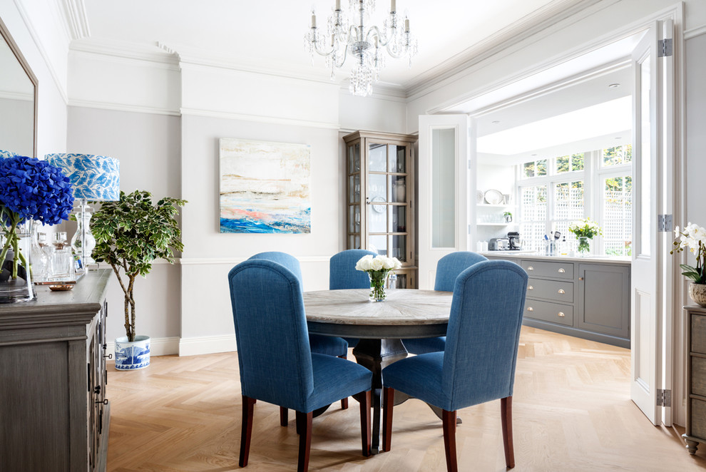 Design ideas for a mid-sized traditional separate dining room in Sussex with grey walls and light hardwood floors.