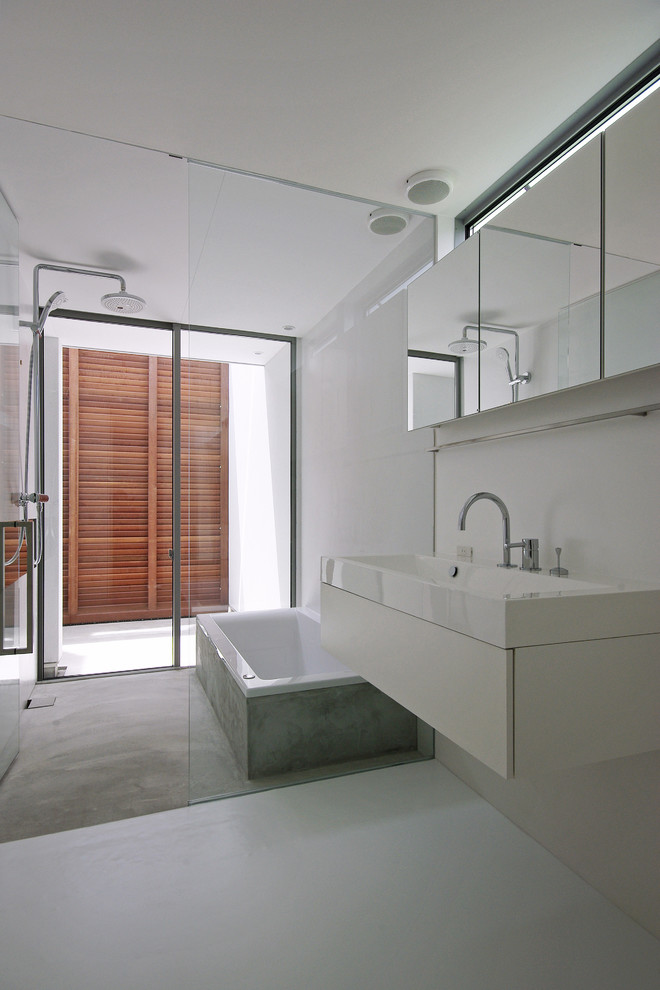 Design ideas for a contemporary wet room bathroom in Other with flat-panel cabinets, white cabinets, a drop-in tub, white tile, white walls, a console sink, white floor and a hinged shower door.