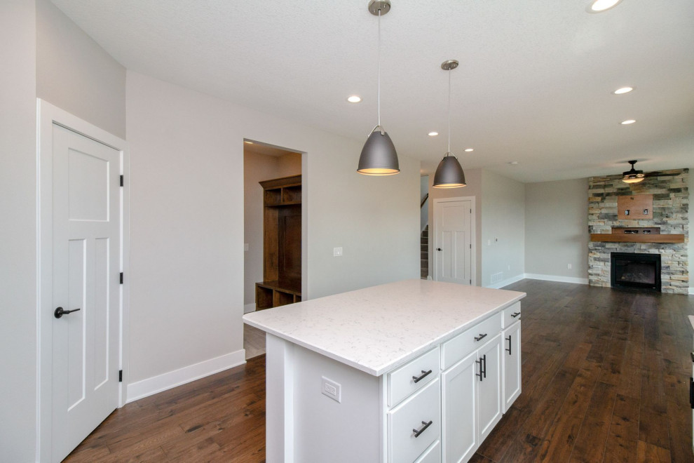 Kitchen - mid-sized transitional dark wood floor and brown floor kitchen idea with an undermount sink, shaker cabinets, white cabinets, quartz countertops, gray backsplash, subway tile backsplash, stainless steel appliances, an island and white countertops