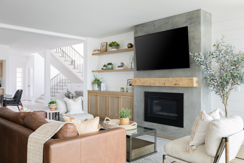 Inspiration for a transitional living room in Orange County with white walls, light hardwood floors, a standard fireplace, a wall-mounted tv and beige floor.
