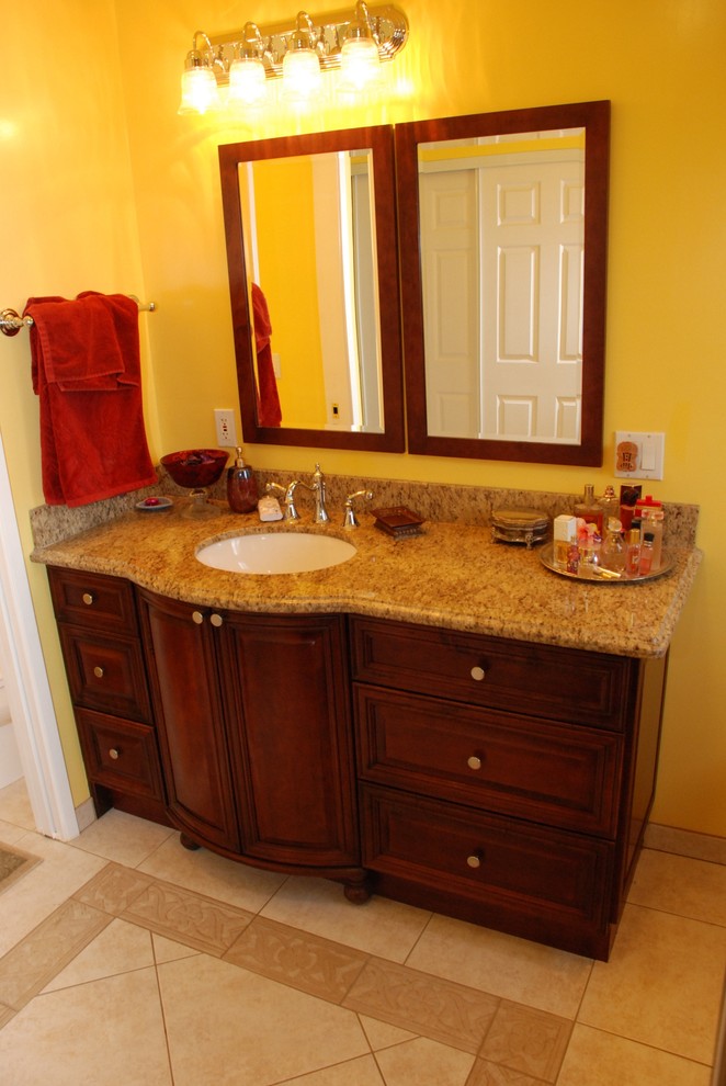 Photo of a large contemporary master bathroom in Orange County with an undermount sink, furniture-like cabinets, distressed cabinets, granite benchtops, an alcove tub, a corner shower, a two-piece toilet, beige tile, ceramic tile, yellow walls and ceramic floors.