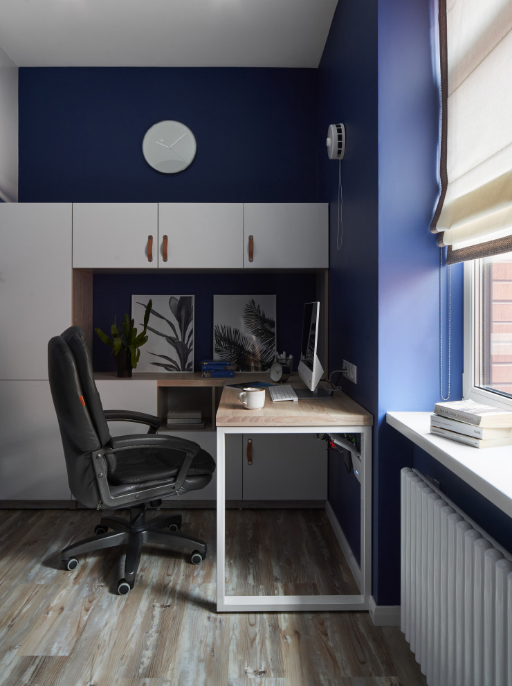 Источник вдохновения для домашнего уюта: маленькое рабочее место в современном стиле с синими стенами, полом из ламината и встроенным рабочим столом для на участке и в саду