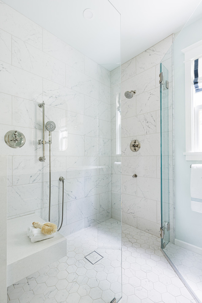 This is an example of a mid-sized transitional master bathroom in Los Angeles with a curbless shower, white tile, marble, blue walls, porcelain floors, white floor, a hinged shower door and a shower seat.
