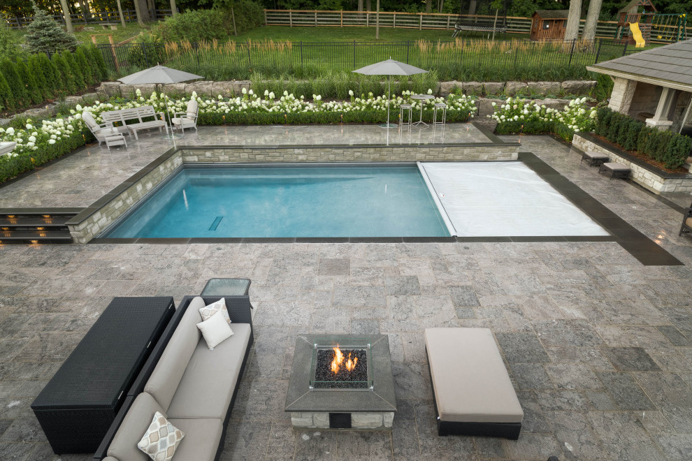 Inspiration for a mid-sized transitional backyard stone and rectangular lap pool fountain remodel in Toronto