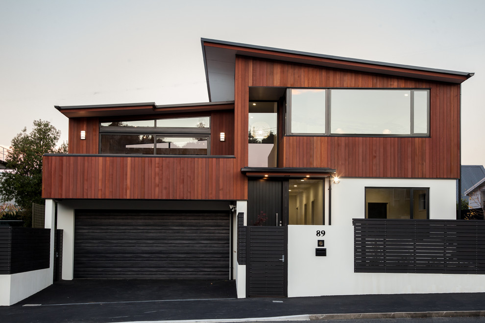 Inspiration for a large contemporary split-level townhouse exterior in Dunedin with wood siding, a flat roof and a metal roof.
